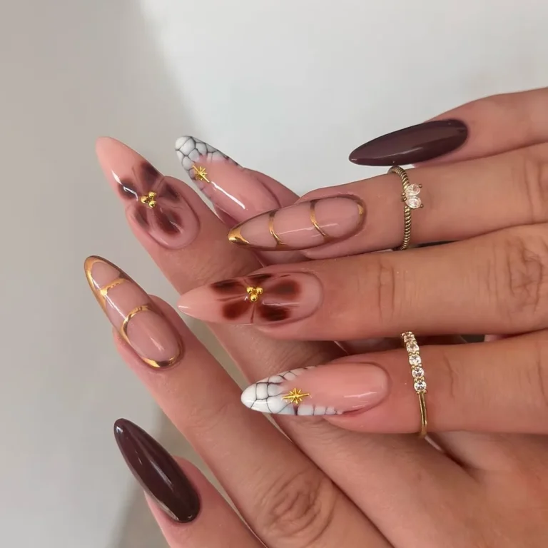 Hand with artistic brown and gold floral nail designs