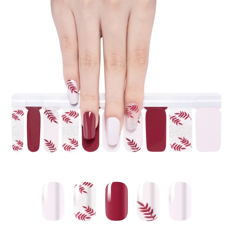 Maroon nails with red leaf designs above matching stickers